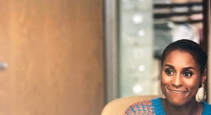 A frame from the TV show Insecure, showing the main character, Issa, from the shoulders up, off-center against a plain background.